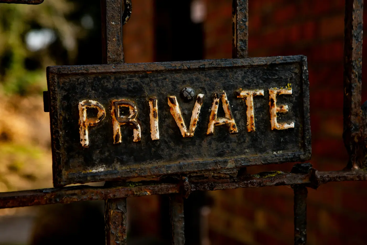 A weathered cast-iron gate sign reading PRIVATE